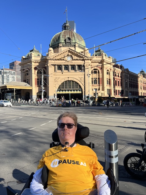 volunteer wearing PauseAI t-shirt in front Flinders Street Station, Melbourne
